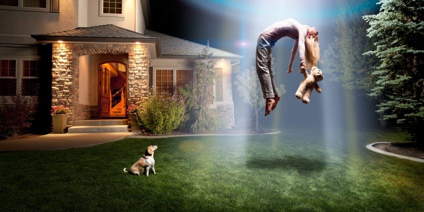 Dog looking at person with teddy bear floating in sky in front of house