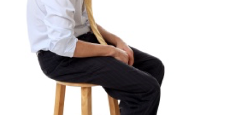 Man in suit sitting slouched on barstool