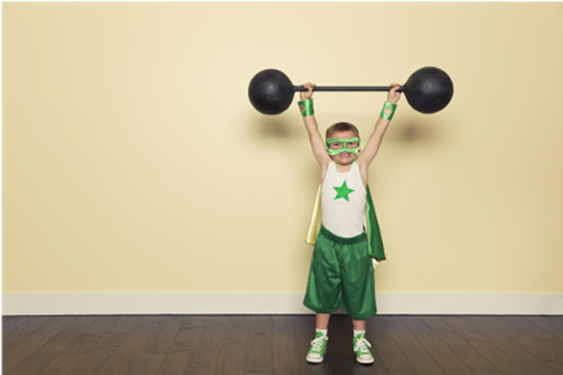 Young boy in superhero costumer holding weights over his head